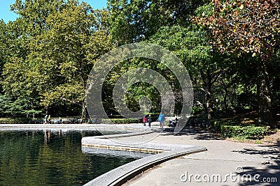 Conservatory Water is model boat pond in Central Park, NYC. The molded curb creates a formal decorative shape for the pond Editorial Stock Photo