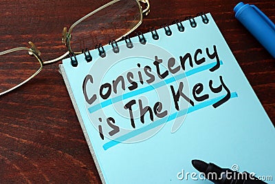 Consistency is The Key written on a notepad. Stock Photo