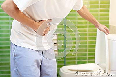 Constipation and diarrhea in bathroom. Hurt man touch belly stomach ache painful. colon inflammation problem, toxic food, Stock Photo