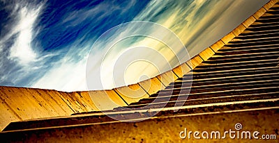 Construction, abstract yellow stairs and beautiful sky with white clouds Stock Photo