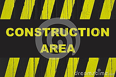 Construction area warning sign with yellow and black stripes painted over cracked wood. Stock Photo