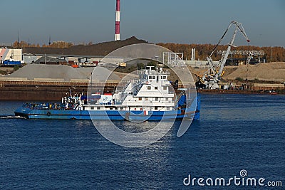 Construction on the banks of the river. A cargo tug goes down the river. Extraction of river sand Stock Photo