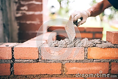 Construction bricklayer worker building walls with bricks, mortar and putty knife Stock Photo