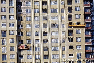 Construction of the building. Workers warm outside walls panels Stock Photo