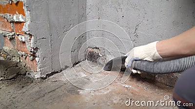 Construction cleaning service sleeve anchor bolt . dust removal with vacuum cleaner. Worker vacuuming concrete floor Stock Photo