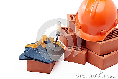 Stack of bricks with masonry trowel, construction hard hat and gloves on white background. Construction concept Stock Photo