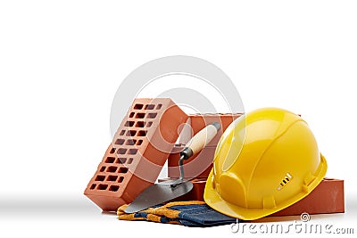 Stack of bricks with masonry trowel, construction hard hat and gloves on white background. Construction concept Stock Photo