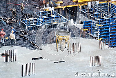 Construction of concrete foundation of new building. Aerial view of construction site workers leveling cement in Stock Photo