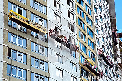 Construction cradles perform facade work. Stock Photo