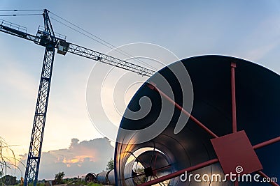 Construction crane for laying large steel pipes for drinking water project under town planning, Large steel pipes at construction Stock Photo