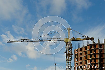 Construction crane on the construction site of a brick residential house Stock Photo