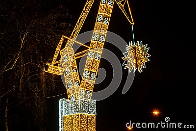 Construction crane symbol of Shipyard Holiday illuminated decorations in Gdansk Poland. Beautiful Christmas fair at Stock Photo