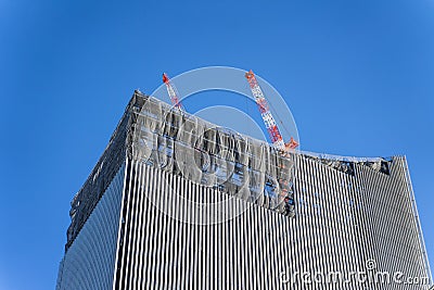 Construction crane on top of tower working to build high skycrapper office building in the development city, clear blue sky Stock Photo