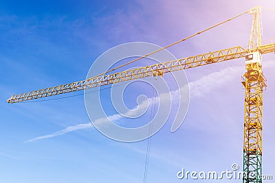 Construction crane tower on background of blue sky. Crane and building working progress. Yellow lifting faucet. Empty Space for te Stock Photo