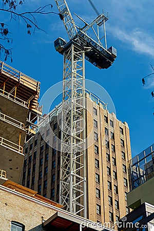 Construction crane with towering buildings in late afternoon sun in parking garage in downtown city san antonio texas Stock Photo