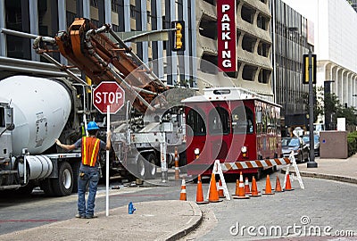 Construction crewman stopping traffic while laying cable Editorial Stock Photo