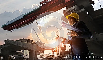Construction engineer manager supervising progress of BTS Station Construction Project and tablet with blueprint in hands. Cranes Stock Photo