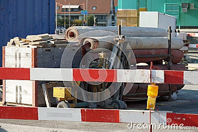 Construction equipment for civil engineering construction site bordered by barrier planks and yellow warning light Stock Photo