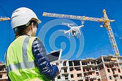 Drone inspection. Operator inspecting construction building site flying with drone Stock Photo