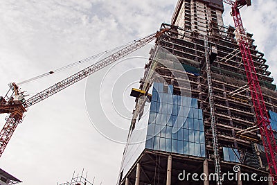 Construction of high-rise building. Construction cranes and skyscraper Stock Photo