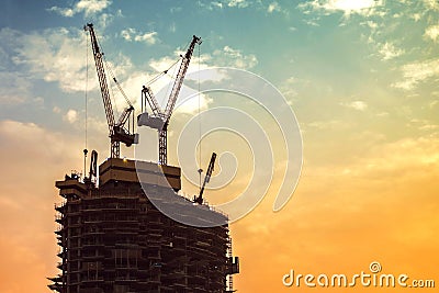 Construction of high-rise building. Construction cranes and skyscraper Stock Photo