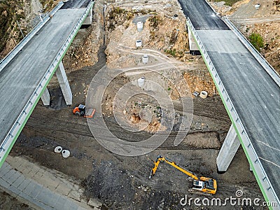 Construction of a highway with viaducts and tunnels in the mountains.Aerial drone view of unfinished highway construction site in Stock Photo