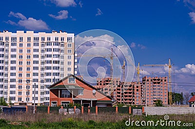 The construction of large apartment buildings displaces small ho Stock Photo