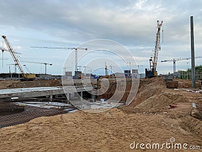 Construction of a large underground infrastructure industrial facility with a foundation using powerful construction cranes Stock Photo