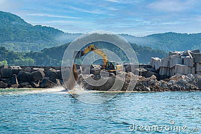 Construction machine builds breakwater, Amasra, Black Sea, Turkey Stock Photo