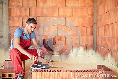 Construction mason worker, bricklayer building brick walls with spatula and mortar Stock Photo
