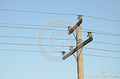 Construction for mounting a overhead power lines on top of column against blue sky Stock Photo