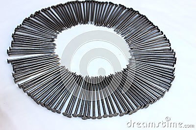 Construction nails lie around on a white background. Steel nails are laid out in the form of a frame with space for text. A pile o Stock Photo