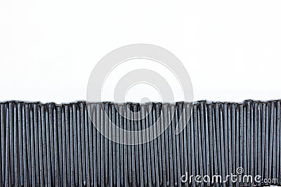 Construction nails lie stripe on a white background. Steel nails are laid out in the form of a frame with space for text. A pile o Stock Photo