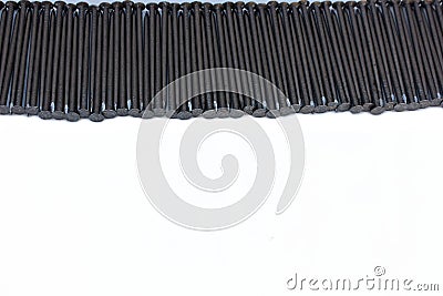 Construction nails lie stripe on a white background. Steel nails are laid out in the form of a frame with space for text. A pile o Stock Photo