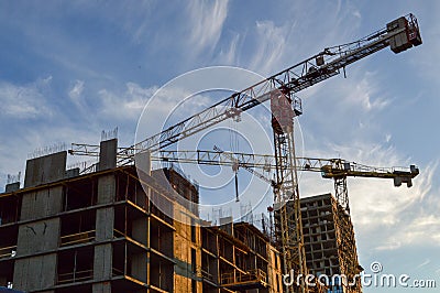 Construction of a new residential concrete house. cranes are folding the new floor. metal rusty pins protrude from concrete blocks Editorial Stock Photo