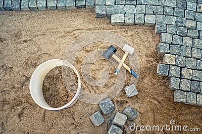 Construction of pavement details, cobblestone pavement, stone blocks and rubber hammers on construction site Stock Photo