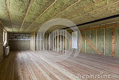 Construction and renovation of big spacious empty unfinished attic room with oak floor, walls and ceiling insulated with rock woo Stock Photo