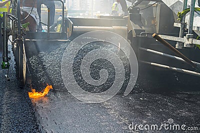 Construction and repair road. Technology and principles of joining road asphalt pavements using asphalt paver machine. Stock Photo