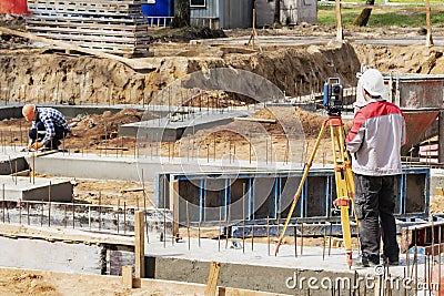 Construction of a residential area. Geodetic stakeout. Surveyor at a large construction site. A man with a tachometer during work Stock Photo