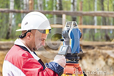 Construction of a residential area. Geodetic stakeout. Surveyor at a large construction site. A man with a tachometer during work Stock Photo