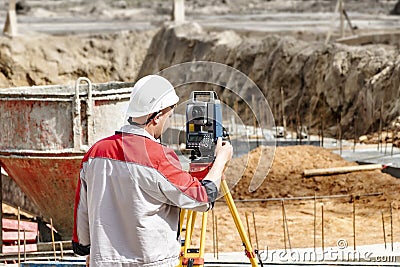 Construction of a residential area. Geodetic stakeout. Surveyor at a large construction site. A man with a tachometer during work Stock Photo