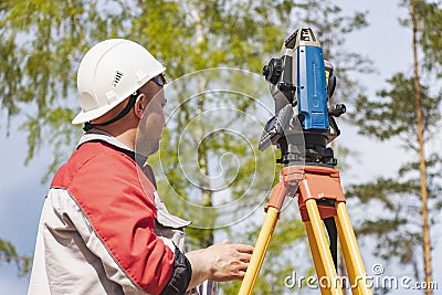 Construction of a residential area. Geodetic stakeout. Surveyor at a large construction site. A man with a tachometer during work Stock Photo