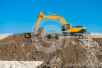 Construction of the road. Excavator modified photo levels the mound of sand. Stock Photo