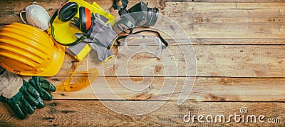 Construction safety. Protective hard hat, headphones, gloves and glasses on wooden background, banner Stock Photo