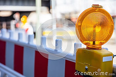 Construction safety. Street barricade with warning signal lamp on a road, blur site background Stock Photo