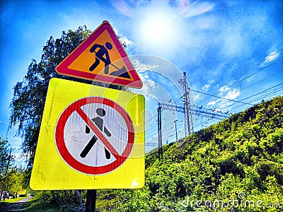 Construction signs warn pedestrians of work ahead and prohibited access by the train tracks on a bright, sunny day Stock Photo