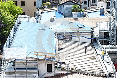Construction site. Construction crew working on the roof sheeting. Editorial Stock Photo