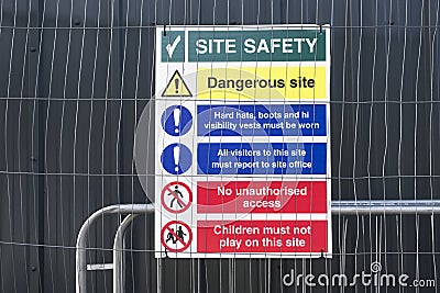 Construction site health and safety message rules sign board signage on fence boundary Stock Photo