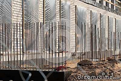 Construction site. Construction of a new building. Unfinished building with reinforced structures with metal mesh. Mud, lots of Stock Photo