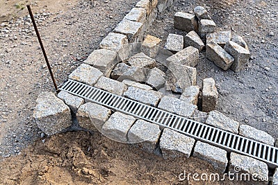 Construction site of a pavement, pile of stones and sand Stock Photo